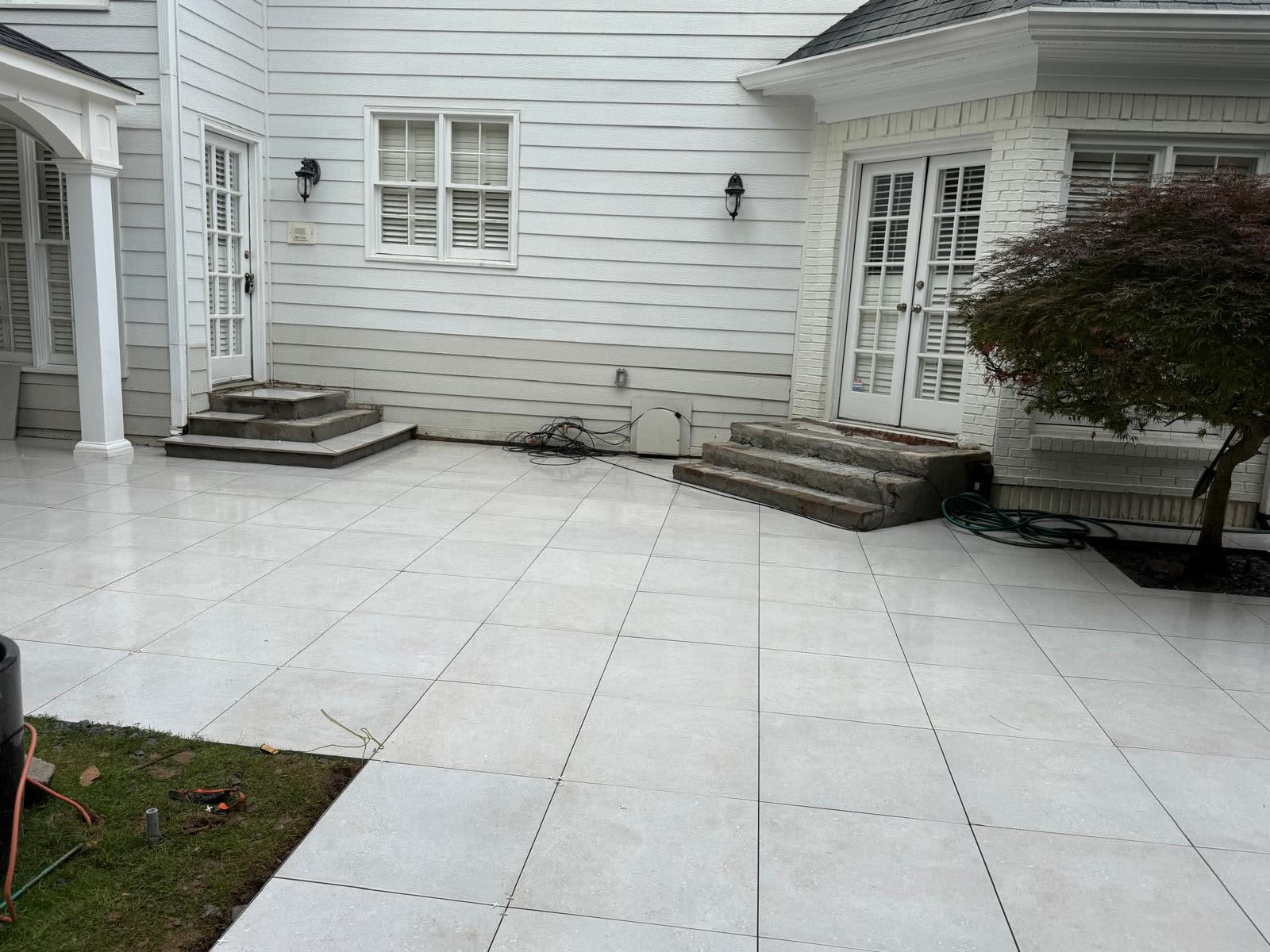 Covered pavilion patio North Georgia — large-format paver field running from the covered area into open patio by Kaizen Scapes