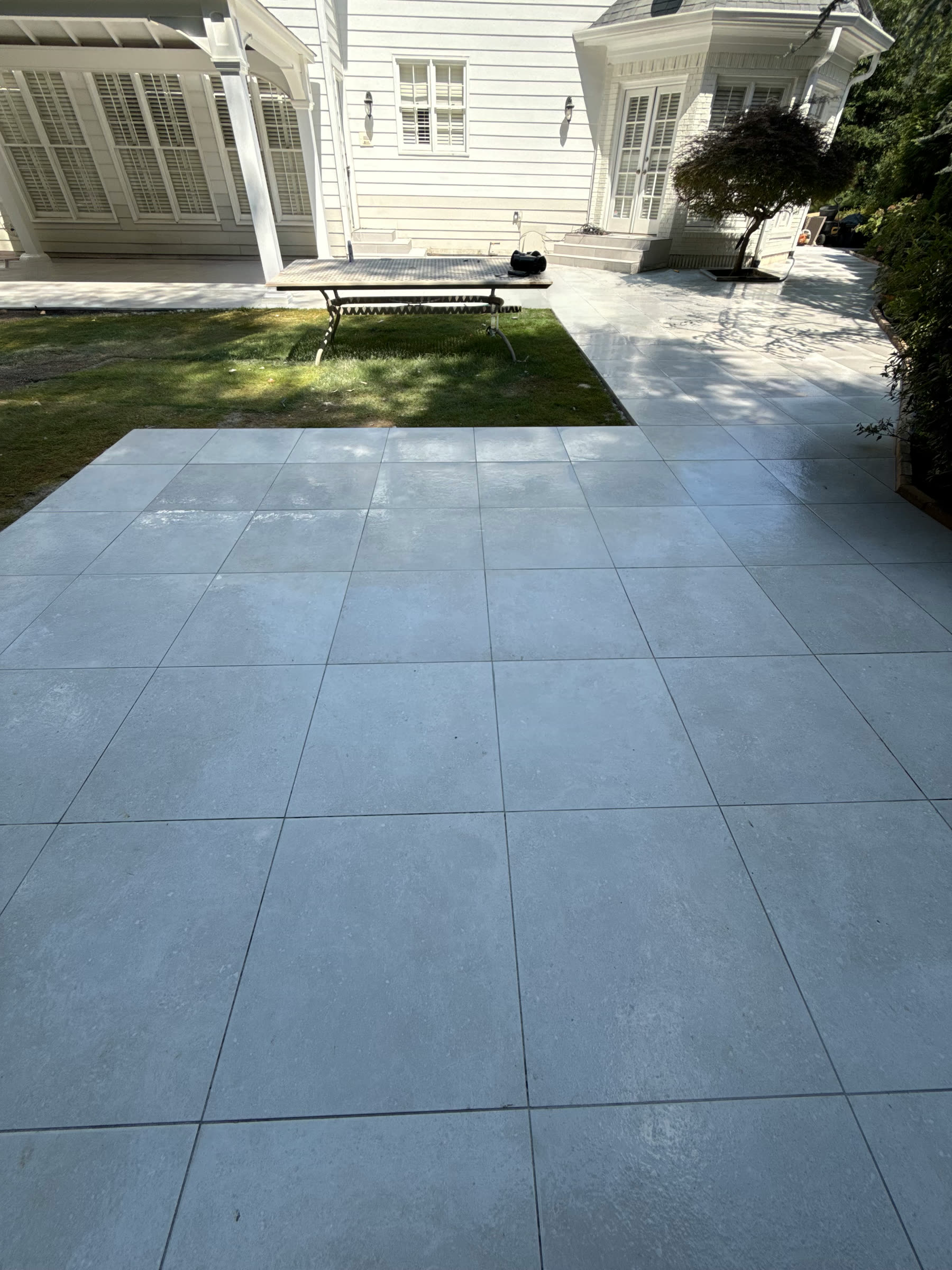 Finished large-format paver patio North Georgia — open field adjoining the covered pavilion, installed by Kaizen Scapes